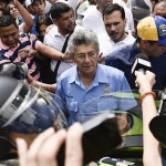 Henry Ramos Allup, jefe del partido de acción democrática de oposición de Venezuela y Presidente de la Asamblea Nacional y Henrique Capriles, un líder de la oposición y el gobernador del estado de Miranda, segundo derecha, enfrentarse a la Policía Nacional venezolana durante una manifestación en apoyo a un referéndum sobre la regla de Presidente Nicolas Maduro en Caracas, Venezuela, el miércoles, 18 de mayo de 2016. Liderado por el dos veces candidato presidencial Capriles, se celebraron manifestaciones en todo el país para presionar a la junta electoral o CNE, para procesar una petición para activar un referendo revocatorio. Fotógrafo: Carlos Becerra/Bloomberg a través de Getty Images