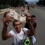 Un hombre muestra un billete de 100 bolívares en Venezuela. El domingo 11 de diciembre el presidente Nicolás Maduro ordenó que esos billetes no circularían más ya que denunció maniobras mafiosas detrás de su uso. ( GEORGE CASTELLANOS/AFP/Getty Images)