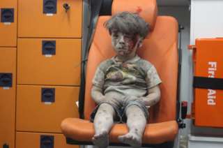 Omran Daqneesh cubierto de polvo y sangre, sentado en una ambulancia tras ser rescatado en Alepo el 17 de agosto 2016.