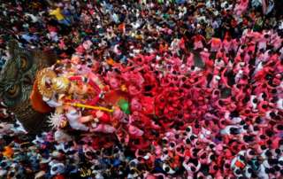 Devotos cargan el ídolo del dios hindú Ganesh, el dios de la prosperidad, por las calles en el último de los 10 días de duración del festival de Ganesh Chaturthi en Mumbai, India.