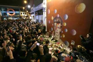 Una multitud frente al mural del cantante David Bowie hecho por el artista Jimmy C, en Brixton, Londres.
