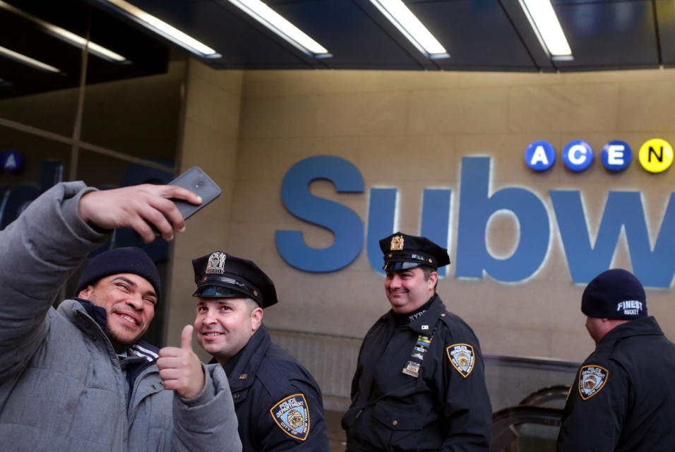 Un transeúnte se toma un selfie con un agente de policía de Nueva York....