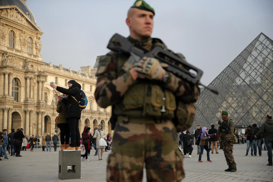 Un soldado en guardia delante del Museo del Louvre, en París, Francia. L...