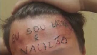 El tatuaje en la frente del joven dice "soy un ladrón y un perdedor".