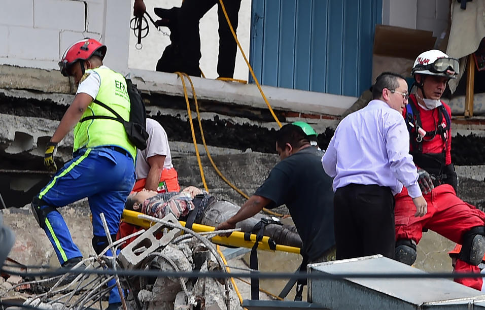 Rescatistas sacan de los escombros de un edificio colapsado a una person...