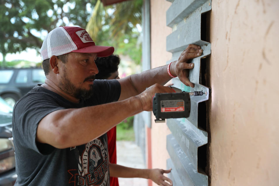 Un residente Homestead, al sur de Miami, protege las ventanas de su casa.