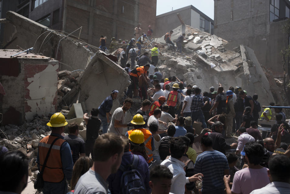 Voluntarios ayudan a remover escombros de un edificio que colaps&oacute;...