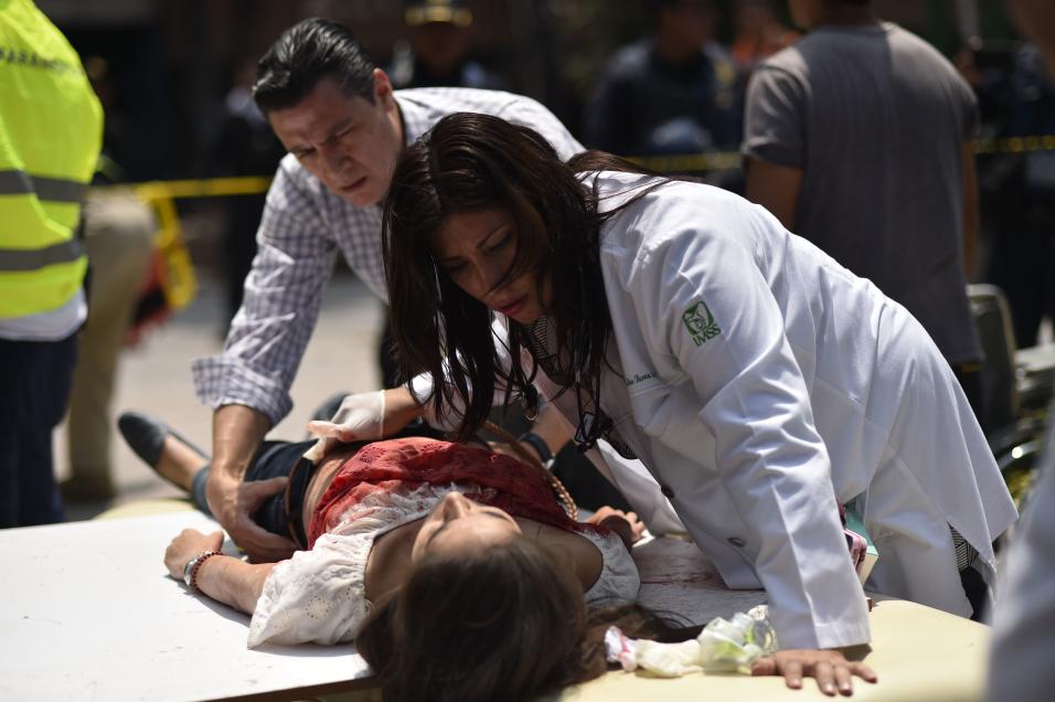 Una mujer herida durante el sismo es asistida por param&eacute;dicos en...