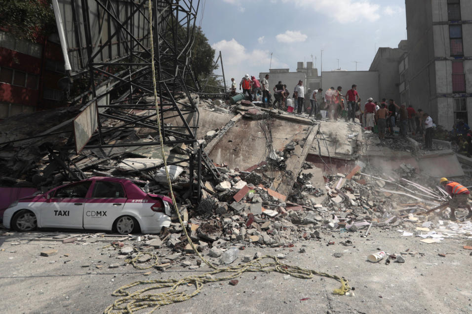 Voluntarios exploran un edificio colapsado en Colonia Roma, en busca de...