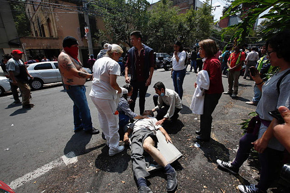 Rescatistas sacan de los escombros de un edificio colapsado a una person...