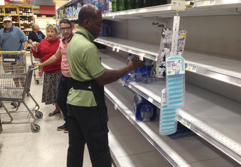 Un empleado de la tienda Publix en Surfside, reabastece en anaquel de ag...