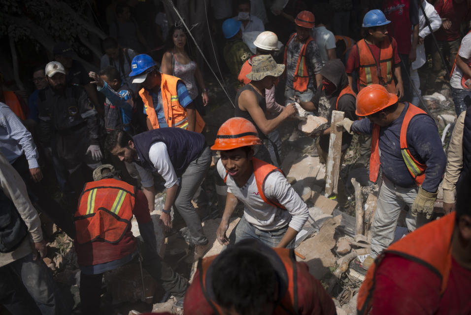 Voluntarios ayudan a remover escombros de un edificio que colaps&oacute;...