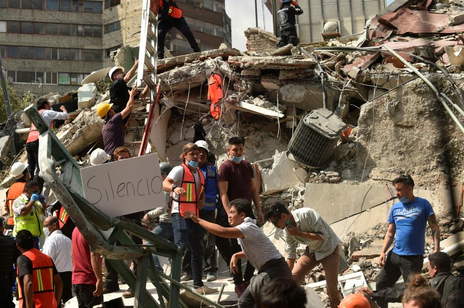 Voluntarios ayudan a remover escombros de un edificio que colaps&oacute;...