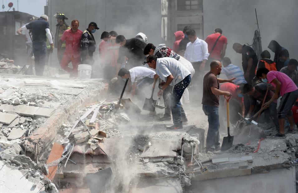 Voluntarios ayudan a remover escombros de un edificio que colaps&oacute;...