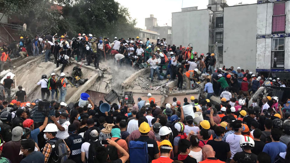 Una multitud de rescatistas y voluntarios buscan a sobrevivientes de un...