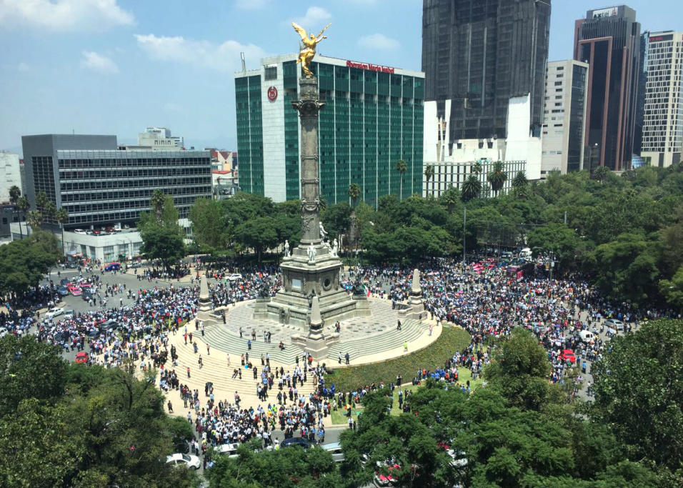 Algunas personas se re&uacute;nen alrededor del monumento del &Aacute;ng...