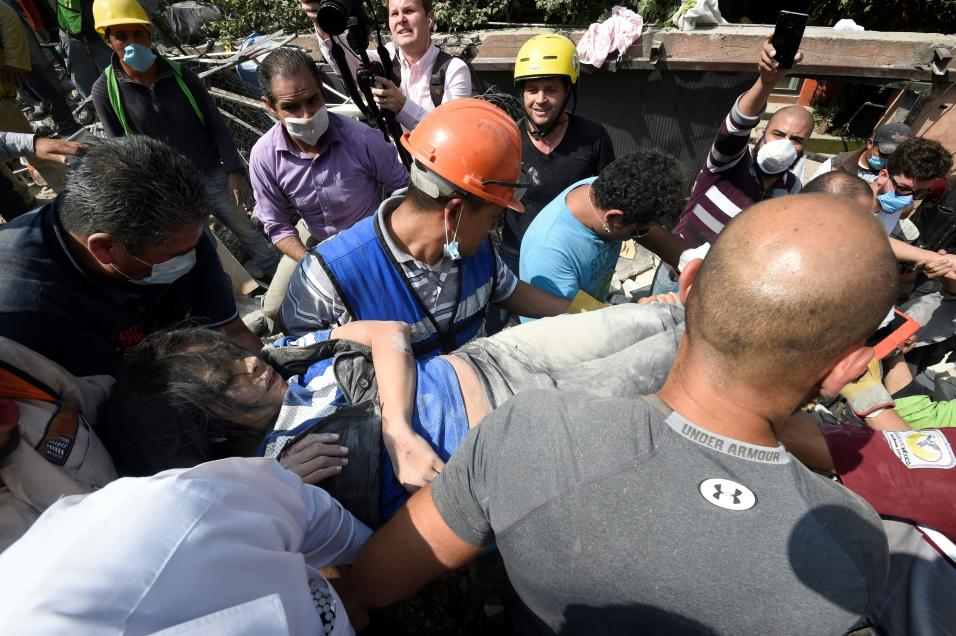 Rescatistas sacan de los escombros de un edificio colapsado a una person...