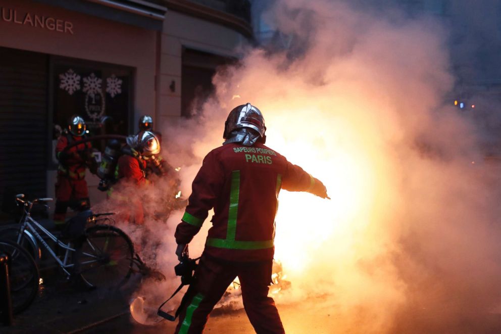 PHOTO: Firefighters try to extinguished a car set on fire by demonstrators during clashes with riot police, in Paris, Dec. 8, 2018.