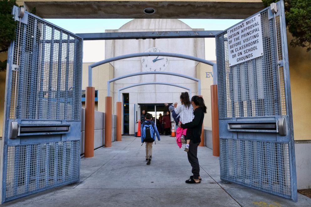 PHOTO: Parents and toddler wave to children as they return to the Evelyn Thurman Gratts Elementary School in downtown Los Angeles, Jan. 23, 2019, following a city wide teachers strike.